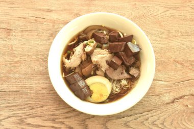 domuz etli ince pirinç eriştesi ve yumurta sarısı kabın üstünde çorba.