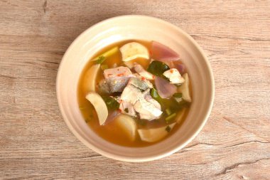 Kaynamış levrek balığı eti ve mantar, Tom yum Thai bitkisi çorbası kasede.