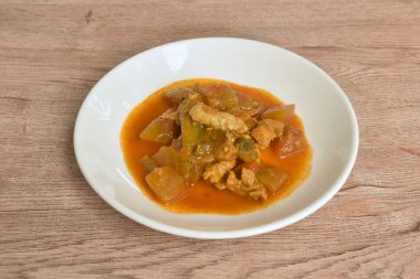 Baharatlı kavun ve tabakta sarı köri soslu domuz eti.