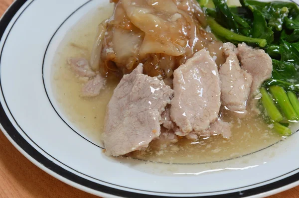 Gebakken noedels met varkensvlees en boerenkool in jus saus — Stockfoto