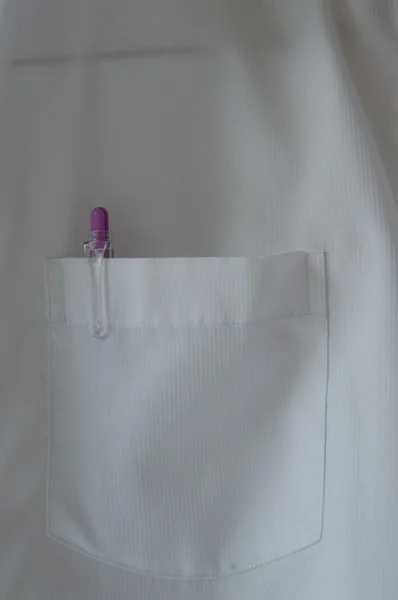 Penna i vit skjorta ficka hängande på väggen — Stockfoto