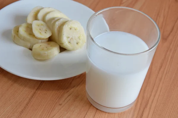 Fatia de banana cultivada e copo de leite — Fotografia de Stock