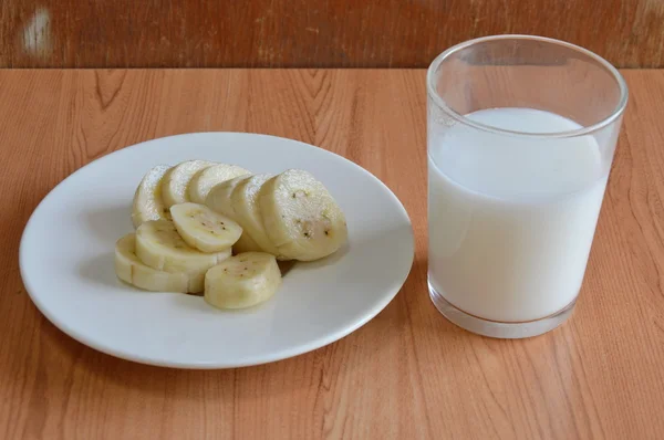 Angebaute Bananenscheibe und Milchglas — Stockfoto