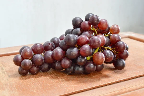 Uva roja sobre mesa de madera — Foto de Stock