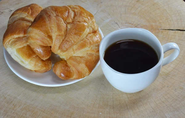 Croissant och kaffe kopp — Stockfoto