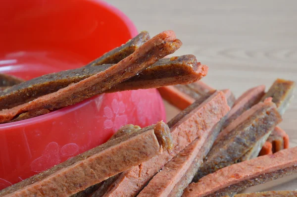 Pollo jerky perro snack en tazón rojo — Foto de Stock