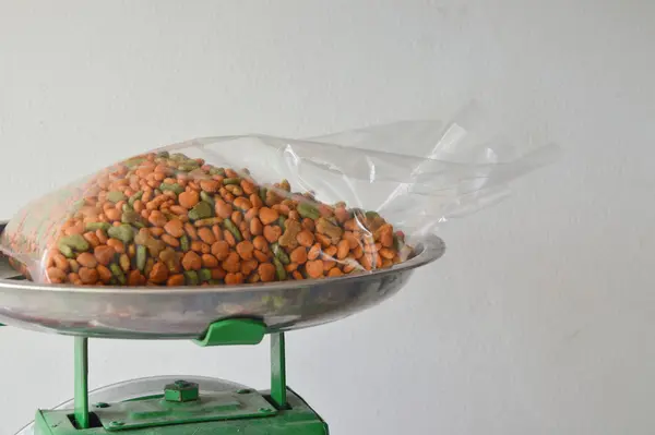 Nourriture pour chien dans un sac en plastique sur plateau de pesée en acier inoxydable — Photo