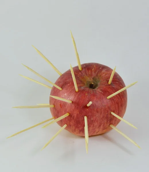 Red apple stab by toothpicks — Stock Photo, Image