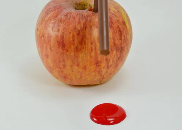 Poignard de paille en pomme rouge et point rouge liquide — Photo