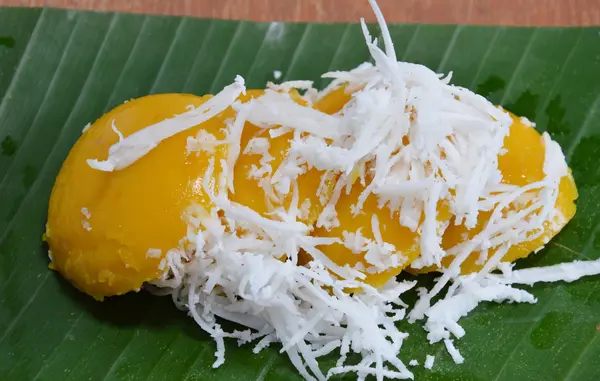 Дитячий пальмовий торт нарізаний кокосовим горіхом на банановому листі — стокове фото