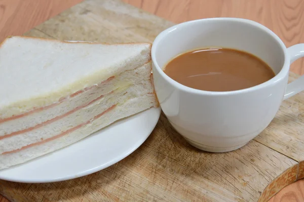 Coffee and bologna sandwich on wooden chop block — Stock Photo, Image