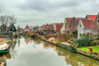 Suda ayna yansıması olan bazı güzel evler. Popüler bir turizm merkezi: Volendam ve Marken - Hollanda 'ya gündüz gezisi. Tipik Hollanda manzarası