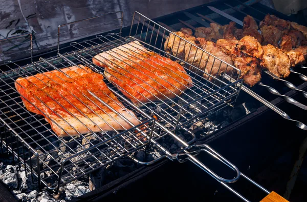 Salmon and pork kebabs grilling outside — Stock Photo, Image