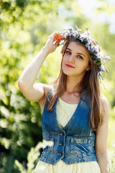 Молодая женщина трогает цветочный венок на голове — стоковое фото