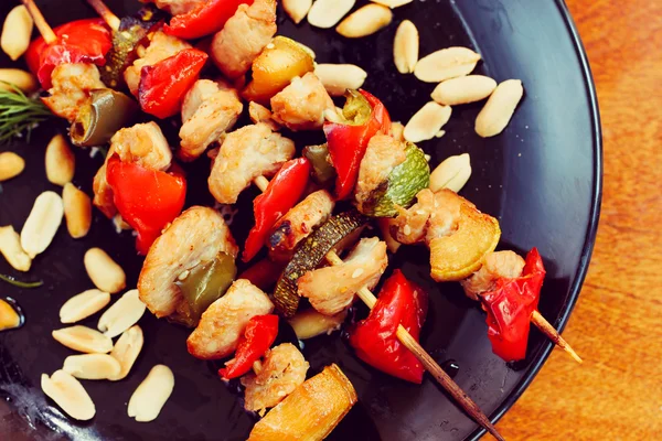 Chicken kebabs with pepper and zucchini on black plate — Stock Photo, Image