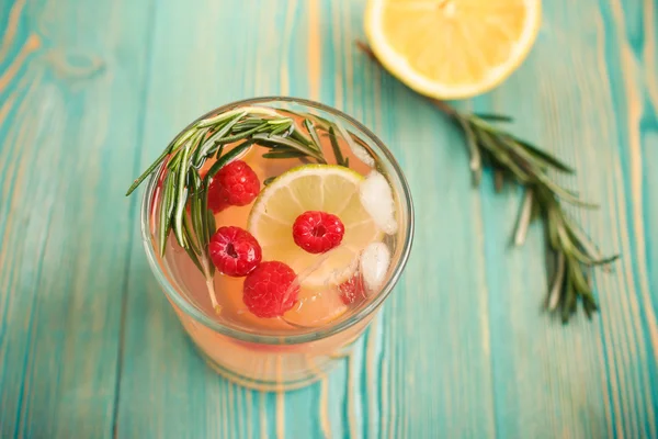 Detox water with raspberry, citrus and rosemary in glass, toned Stockfoto