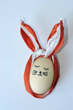 Kapalı gözlü, krep kağıdından yapılmış uzun kahverengi ve beyaz kulaklı el yapımı Paskalya tavşanı.