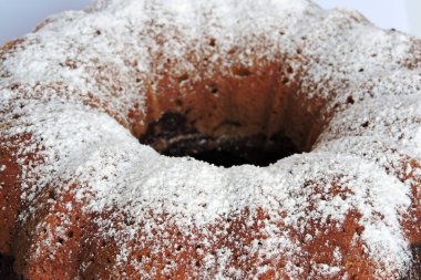 Bir ev yapımı Paskalya pastası pudra şekeriyle serpilmiş ve beyaz bir tabakta servis edilmiş, izole edilmiş.