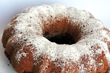 Bir ev yapımı Paskalya pastası pudra şekeriyle serpilmiş ve beyaz bir tabakta servis edilmiş, izole edilmiş.