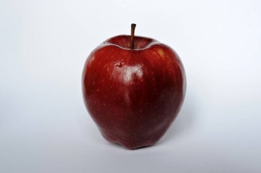 Beyaz üzerine izole edilmiş parlak koyu kırmızı bir elma.