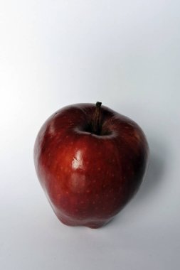 Beyaz üzerine izole edilmiş parlak koyu kırmızı bir elma.