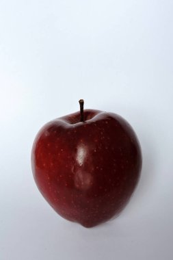 Beyaz üzerine izole edilmiş parlak koyu kırmızı bir elma.