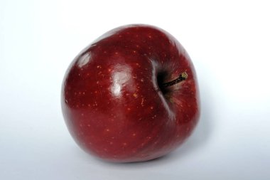 Beyaz üzerine izole edilmiş parlak koyu kırmızı bir elma.