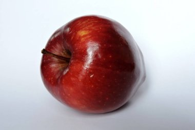 Beyaz üzerine izole edilmiş parlak koyu kırmızı bir elma.
