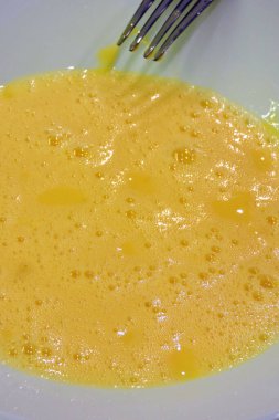 Çatalla çırpılmış köpüklü yumurta, beyaz tabakta çırpılmış yumurta.