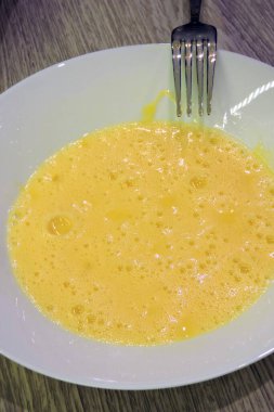 Çatalla çırpılmış köpüklü yumurta, beyaz tabakta çırpılmış yumurta.