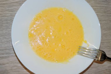 Çatalla çırpılmış köpüklü yumurta, beyaz tabakta çırpılmış yumurta.