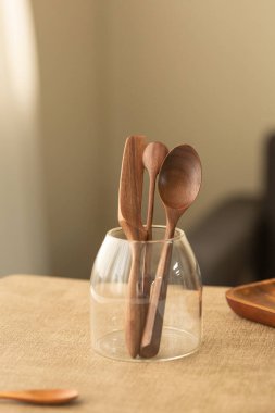 Clear Holder 'da Doğal Tahta Kaşıklar ve Spatula Masadaki cam vazoda tahta kaşıklar.