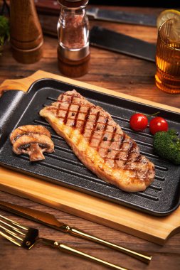 Orta pişmiş biftek, taze vişneli domates ve biberiyeli garnitür.