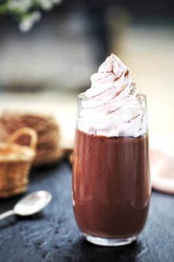 Glass jar filled with roasted coffee beans on a kitchen cabinet shelf