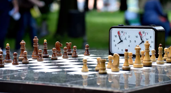 Klocka och schack styrelsen i parken — Stockfoto