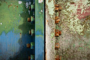 Paslı fındık ve cıvatalar, iki paslı eski metal boruyu birbirine bağlıyor..