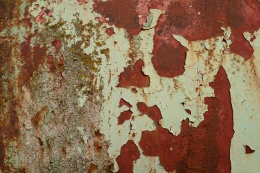Paslı metal bir yüzey, eski boya katmanları soyulmuş..