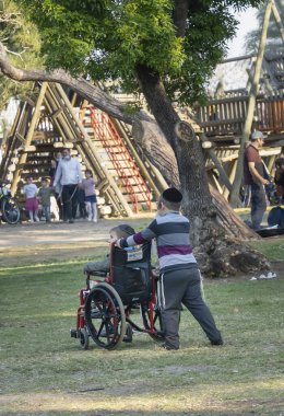 Tel Aviv, İsrail - 31 Mart 2021: Engelli kardeşinin tekerlekli sandalyesini Tel Aviv, İsrail, Park.