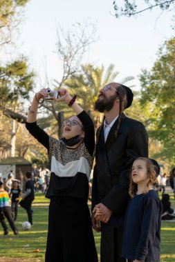 Tel Aviv, İsrail - 31 Mart 2021: Bir baba ve çocukları İsrail 'in Tel Aviv kentindeki bir halat macera parkında ziyaretçilere bakıyorlar.