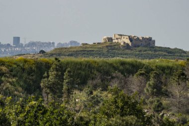 Rosh HaAyin, İsrail - 29 Mart 2021: Migdal Tsedek ulusal parkının tepesindeki tarihi bina. Arka plandaki şehir Rosh Ha 'ain..