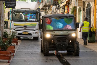 Kudüs, İsrail - 3 Haziran 2021 Kudüs, İsrail, cadde üzerinde asılı renkli şemsiyeler arabaların ön camlarına yansıdı.