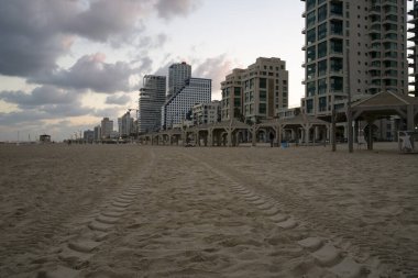 İsrail, Tel Aviv 'de kumsalda, şafakta plajda lastik izleri bırakıldı. Arka planda görülen oteller.