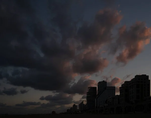 太陽がイスラエルのテルアビブ上空で昇る時に 雲は赤く塗られる — ストック写真