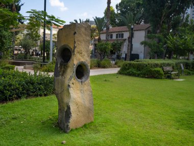 Tel Aviv, İsrail - 19 Ağustos 2021: Tel Aviv 'deki Sarona kompleksinin yenilenmiş eski evleri yakınında bir uğultu taşı.