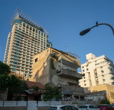 Tel Aviv, İsrail - 20 Ağustos 2021: Tel Aviv caddesindeki modern binalar arasında terk edilmiş eski bir bina.