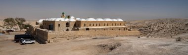Nabi Musa, Israel - September 26th, 2021: The exterior of the prophet Moses mausoleum in the Judea desert, Israel, and its adgacent grave yard. clipart
