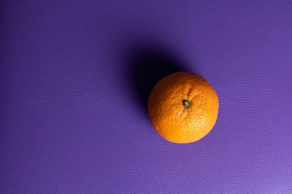 Orange Mandarine Auf Violettem Hintergrund Mit Seitlicher Beleuchtung — Stockfoto
