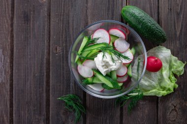 Tahta zemin üzerinde taze turp ve salatalık salatası manzarası