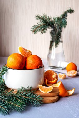 Masadaki vazoda köknar dalları olan beyaz bir kasede sulu mandallar.