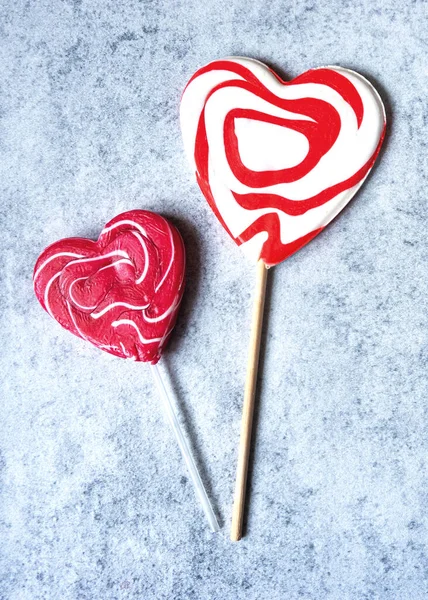 Draufsicht auf zwei herzförmige Lollypops auf grauem Betongrund, Valentinstag-Konzept — Stockfoto